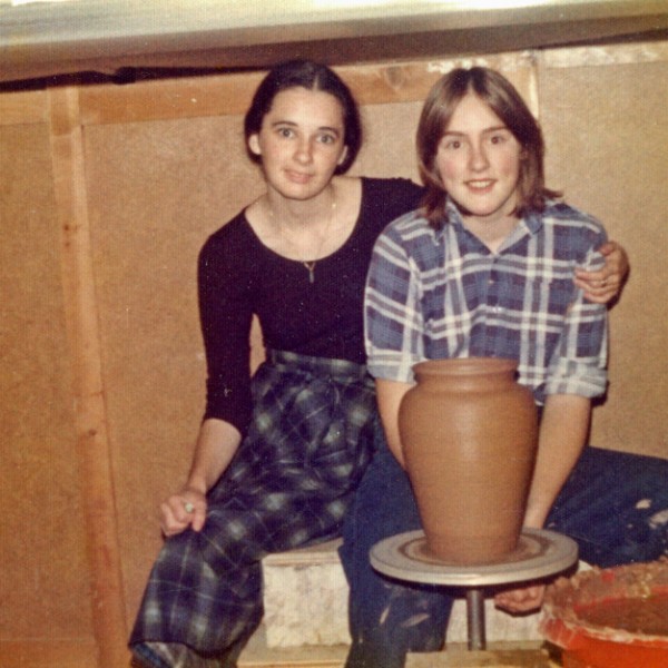 Mary Fox in her first studio, throwing on a kick wheel pictured here with her future sister in law. 1976